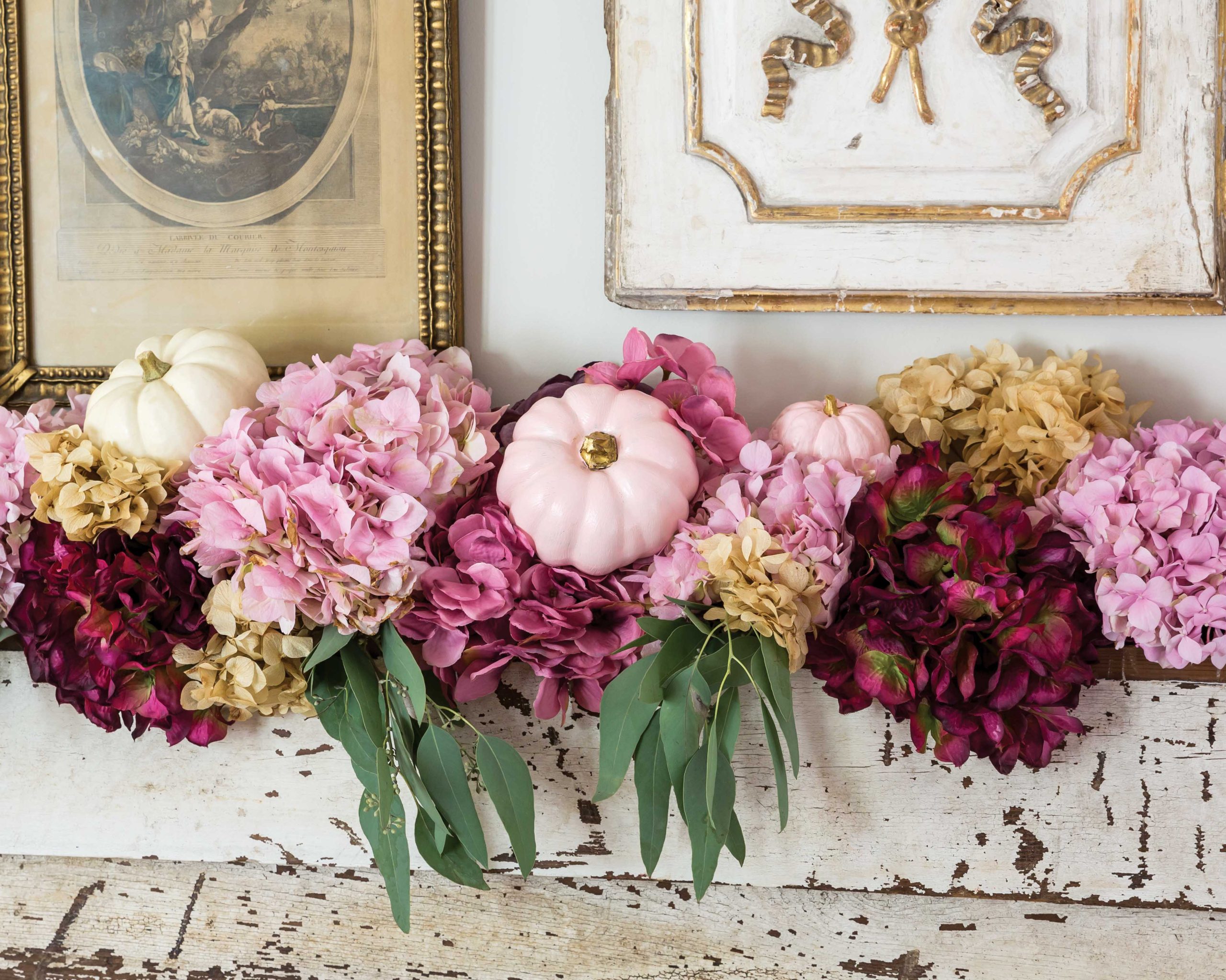  Pale pink pumpkins join vibrant hydrangea flowers atop a fireplace mantel.