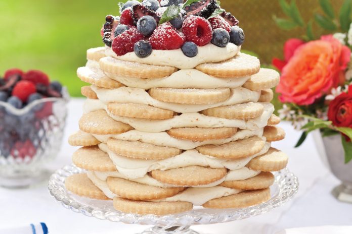 Old-Fashioned Creamy Orange Icebox Cake pairs vanilla-bean shortbread with a zesty buttercream kissed with citrus. A mound of freshly picked berries and a light dusting of confectioners' sugar crowns the show-stopping treat.