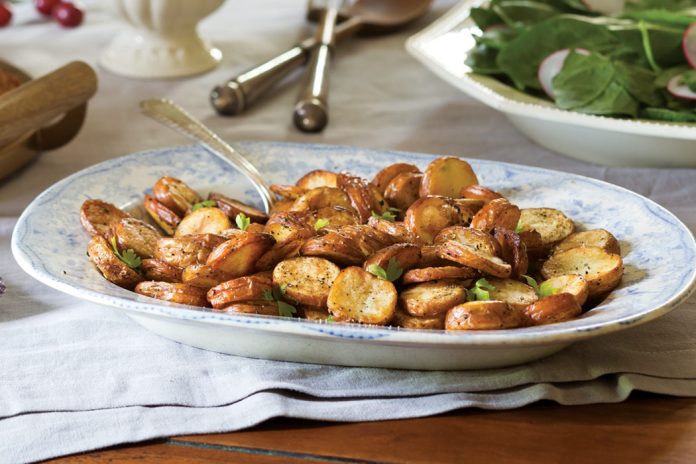 Roasted Salt-and-Vinegar Potatoes—baby reds sliced, cooked, and simply dressed—prove a comforting staple.