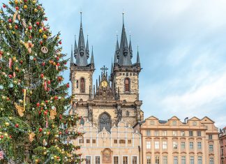 A massive outdoor Christmas tree stands outside the Church of Our Lady before Tyn, the spires of which rise above the square.