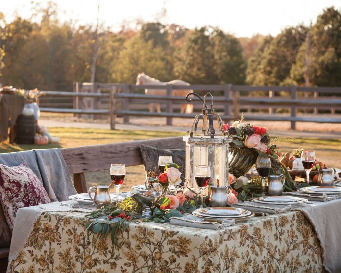rranged outside the stables, a romantic table is laden with colorful flowers, lush greenery, and Julie Wear china.