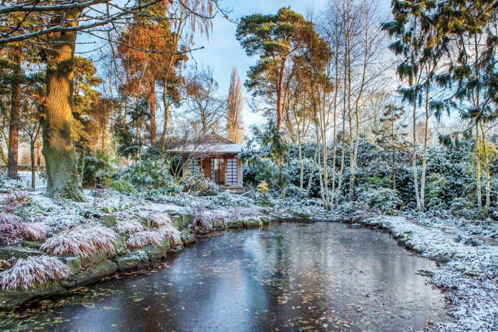 t the edge of a frozen lake, surrounded by snow-dusted trees, sits a small building that is one of this garden’s fetching features.