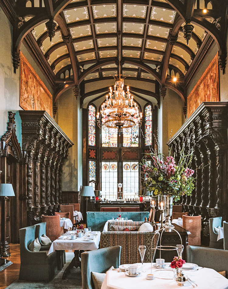 Ornate decorations, including stained glass windows and a grand chandelier, dress this tearoom inside Adare Manor.